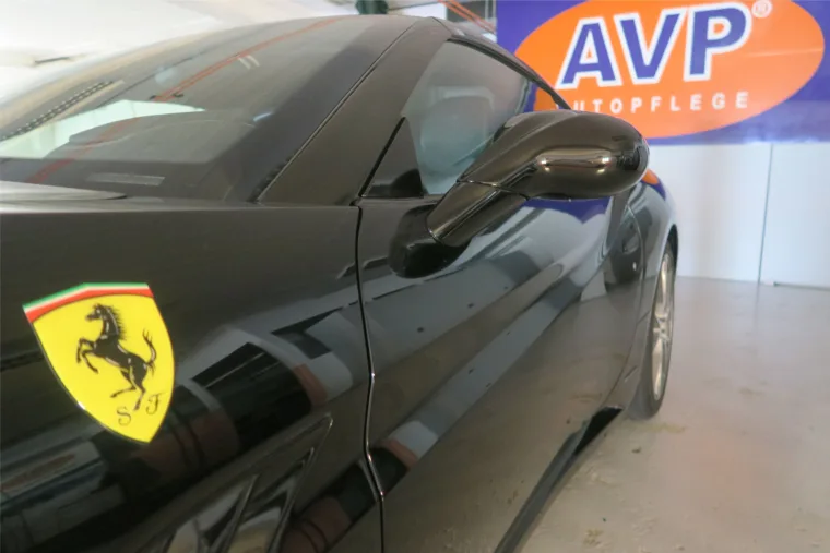 Schwarzer Ferrari mit kontrolliertem Lackfinish in der AVP Werkstatt