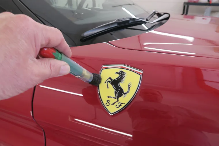 Punktuelle Lackausbesserung neben dem Ferrari Emblem