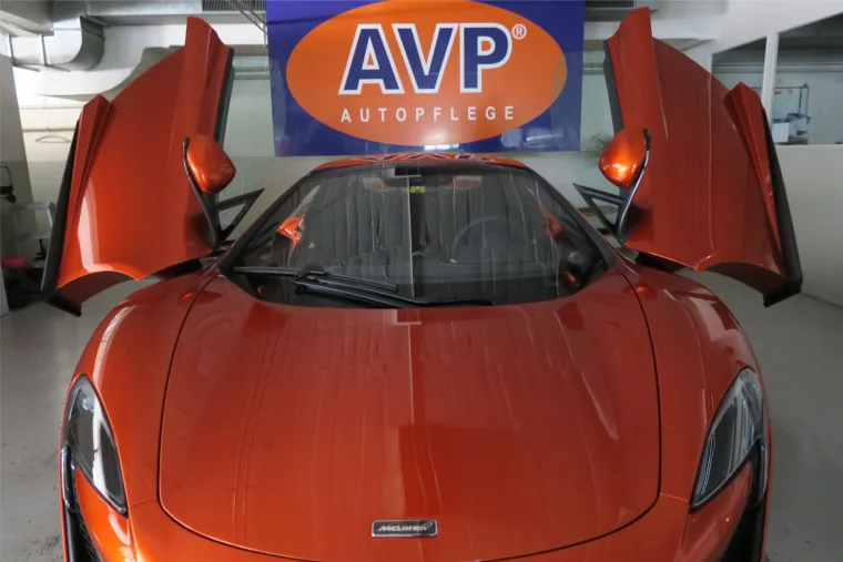 Orangefarbener McLaren nach der Aufbereitung vor dem AVP Logo