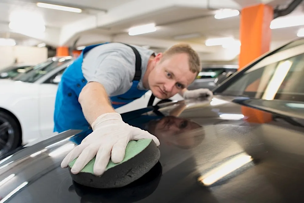 Politurauftrag von Hand an einer Motorhaube in der AVP Werkstatt